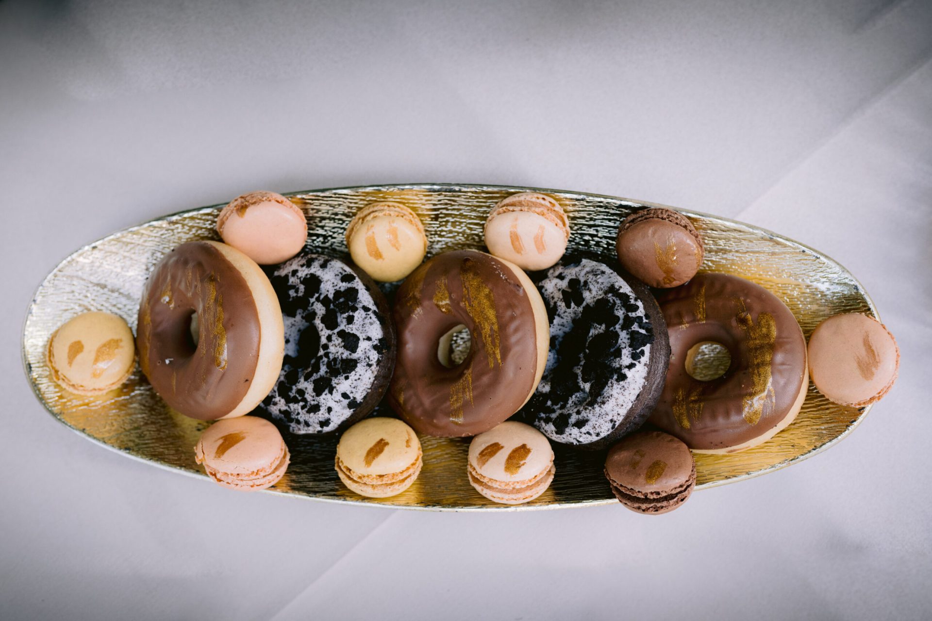 Platou oval cu gogoși glazurate și macarons, realizate de Cofetăria Giumbo