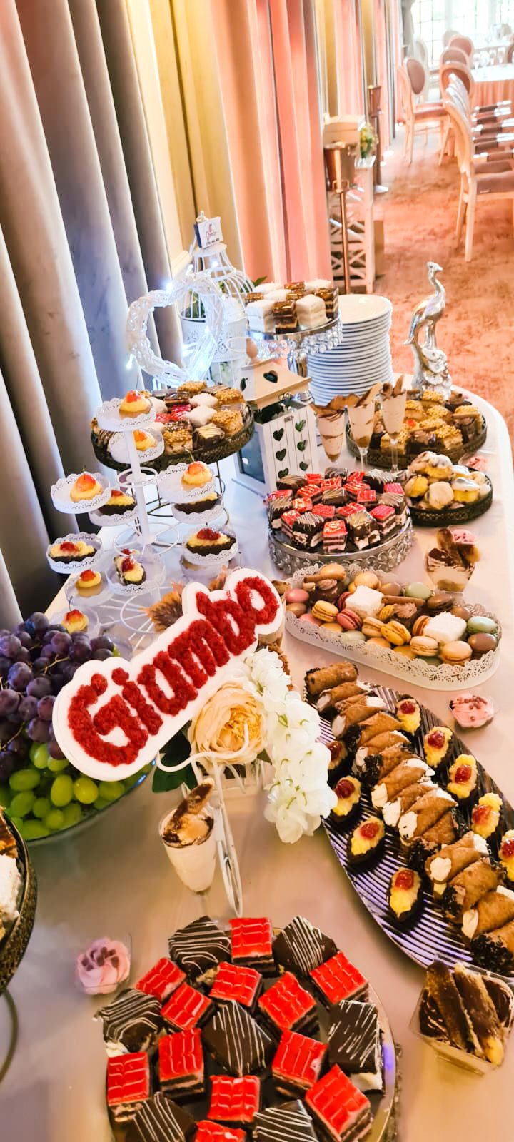 Masă dulce de eveniment pregătită de Cofetăria Giumbo, cu prăjituri diverse aranjate pe mai multe niveluri