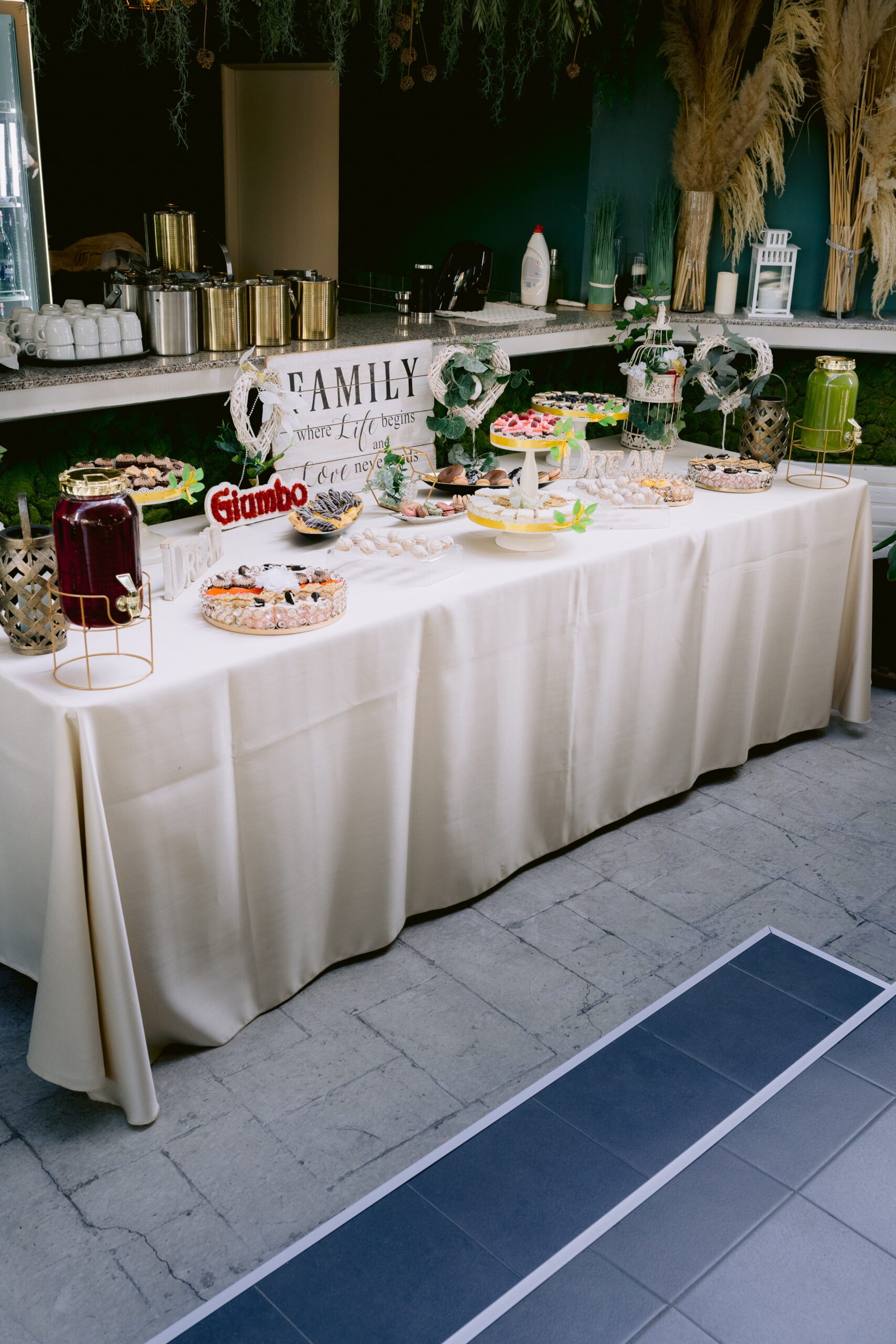 Masă dulce de eveniment pregătită de Cofetăria Giumbo, aranjată pe o masă lungă cu față albă